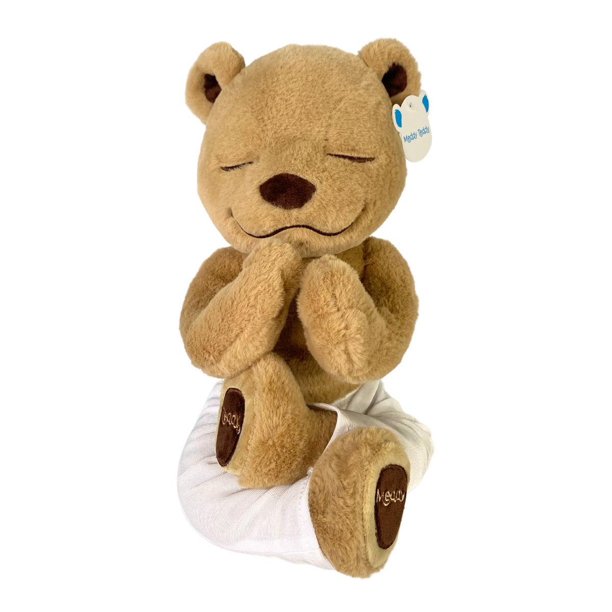 Meddy Teddy in white yoga pants, doing lotus pose with hands in praying position